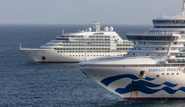 Carlisle Bay, Barbados, West Indies - May 16, 2020: Emerald Princess cruise ship anchored next to Barbados. Close view of the ship's bow with Seabourn Odyssey cruise ship in the background