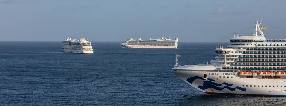 Carlisle Bay, Barbados, West Indies - May 16, 2020: Emerald Princess cruise ship anchored next to Barbados. View of the ship's bow with Caribbean Princess and Aida Luna cruise ships in the background