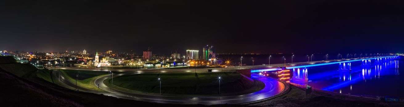 Night panorama of a bridge lit up in the darkness and Barnaul cityscape in Russia
