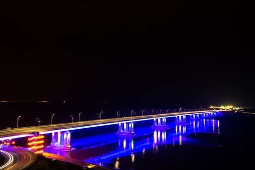 Perspective view of a bridge lit up at night. Barnaul City, Russia
