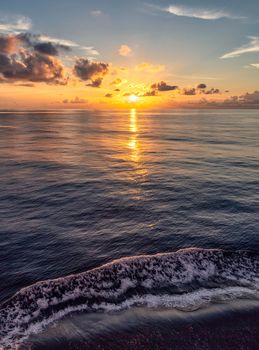 Beautiful Caribbean sunset with water splashing in the foreground and orange-and-blue sky in the background