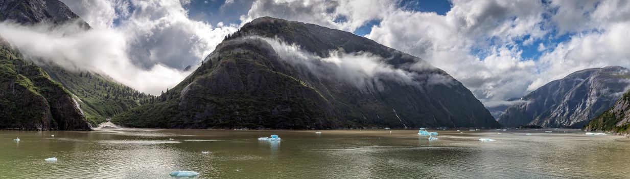 Beautiful panoramic view of mountains covered with clouds in Alaskan fjord