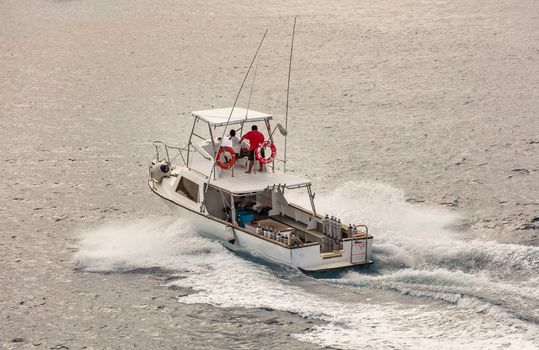 Fishing boat moving very fast with water splashing around it