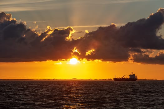 Tanker sailing off the coast of Belize, Central America with beautiful sunset behind it as a background