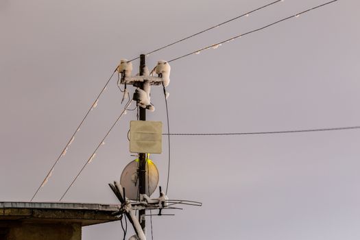 Frozen 5 GHz wireless antenna repeater pillar at winter night.