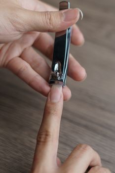 Man using nail clipper clipping her fingernails.