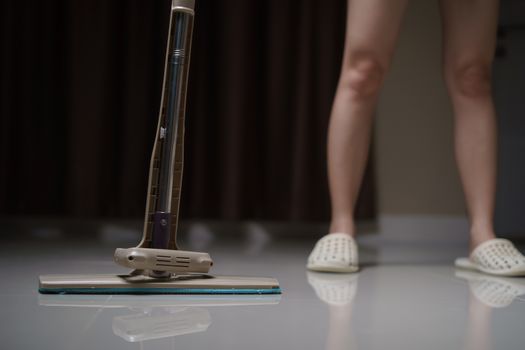 Woman using a flat wet-mop cleaning floor in the house. protect virus covid-19