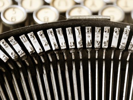 the iron hammers of an old typewriter with the keys blurred in the background. Typing and obsolete technology. Vintage object