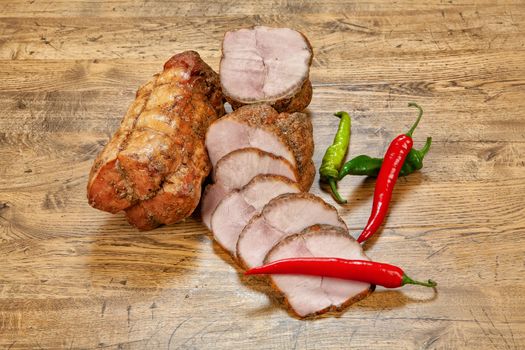Ham sausage and pepper on a wooden desk