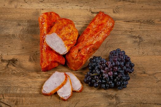 Ham sausage and grapevine on a wooden desk