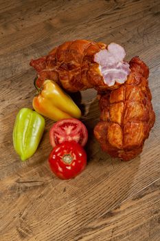 Ham sausage, tomato and pepper on a wooden background
