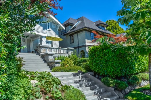 Concrete stairway to main entrance of residential house over the front yard