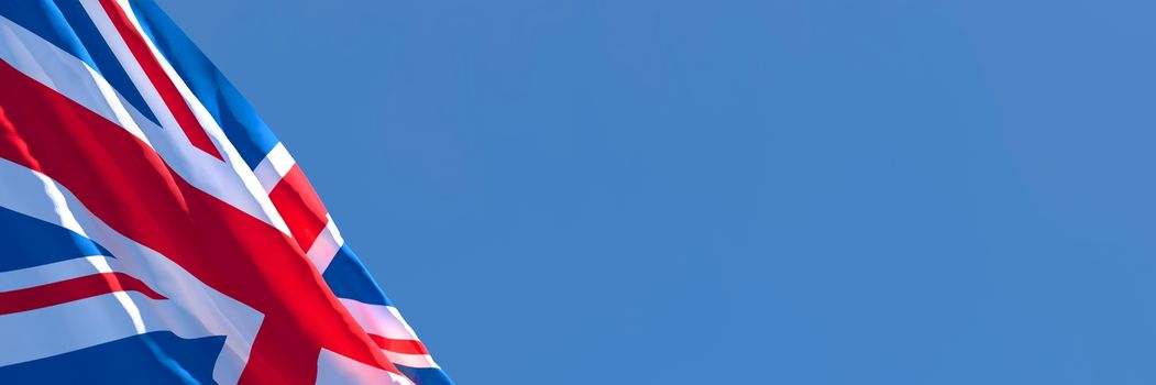 3D rendering of the national flag of British waving in the wind against a blue sky