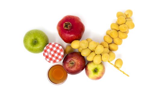 Rosh Hashanah, Jewish New Year, Traditional Symbols, Honey in a glass jar, Pomegranates, Dates, Red And Green Apples. Isolated On A White Background