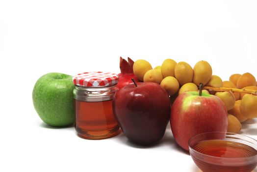 Rosh Hashanah, Jewish New Year, Traditional Symbols, Honey in a glass jar, Pomegranates, Dates, Red And Green Apples. Isolated On A White Background