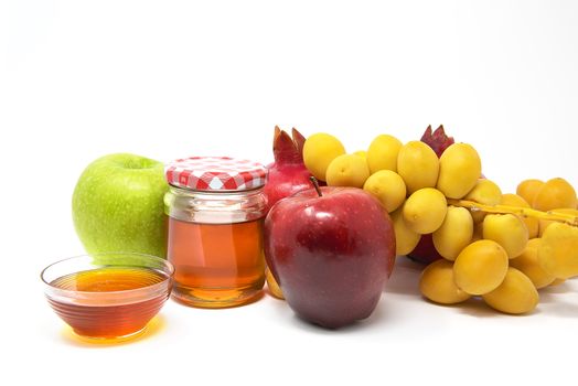 Rosh Hashanah, Jewish New Year, Traditional Symbols, Honey in a glass jar, Pomegranates, Dates, Red And Green Apples. Isolated On A White Background