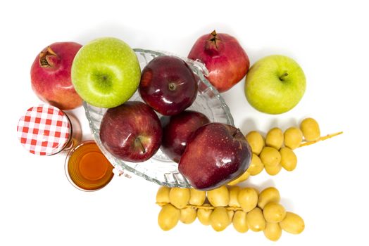 Rosh Hashanah, Jewish New Year, Traditional Symbols, Honey in a glass jar, Pomegranates, Dates, Red And Green Apples. Isolated On A White Background