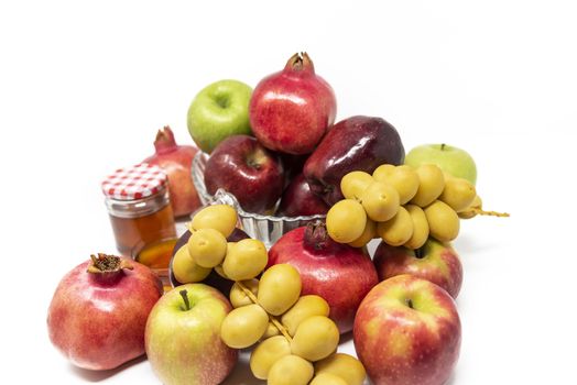 Rosh Hashanah, Jewish New Year, Traditional Symbols, Honey in a glass jar, Pomegranates, Dates, Red And Green Apples. Isolated On A White Background