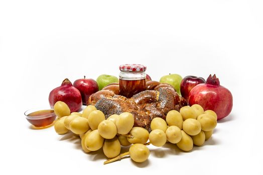 Rosh Hashanah, Jewish New Year, Traditional Symbols, Honey in a glass jar, Pomegranates, Dates, Red And Green Apples, Challah Bread. Isolated On A White Background