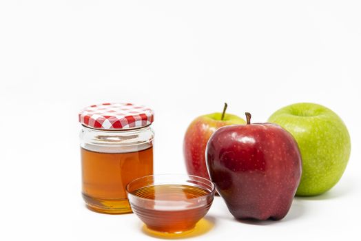 Rosh Hashanah, Jewish New Year, Traditional Symbols, Honey in a glass jar, Red And Green Apples. Isolated On A White Background