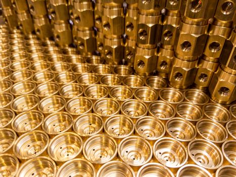 shiny brass metal threaded hexagonal fitting parts, abstract perspective industrial close-up background.