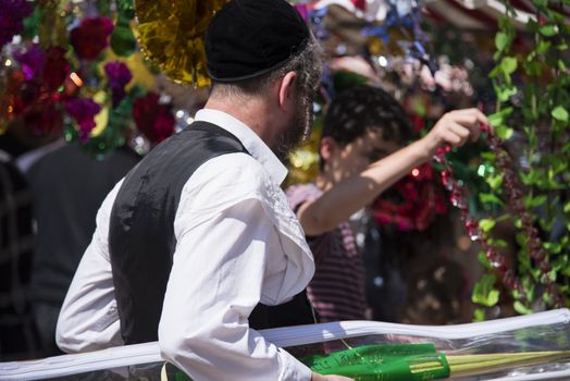 Jewish man wearing kippah. Sukkot's four species festival. Palm branch. Sukkah decorations