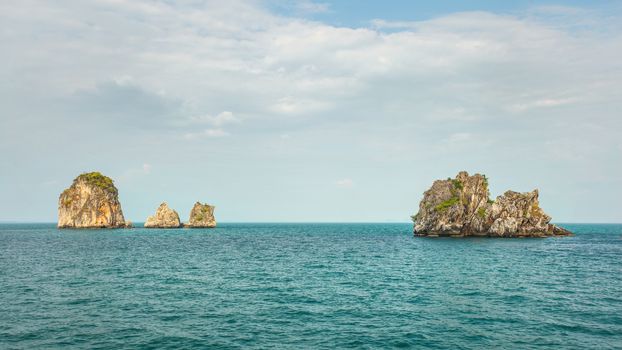 Four of hundreds small uninhabited karst rocky islands with green flora on top. Andaman sea between Phi Phi and Ao Nang, Thailand