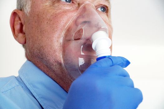 old man breathing through an inhaler, portrait close up