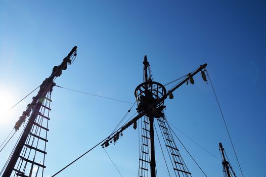 the top of the mast of an old ship against the backdrop of a sunny sky, copy space