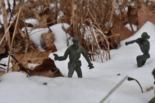 A Toy Soldier Holding a Pistol in a Deep Snowy Field