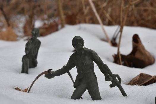 A Toy Soldier Leaning Back to Throw a Grenade in Knee-Deep Snow