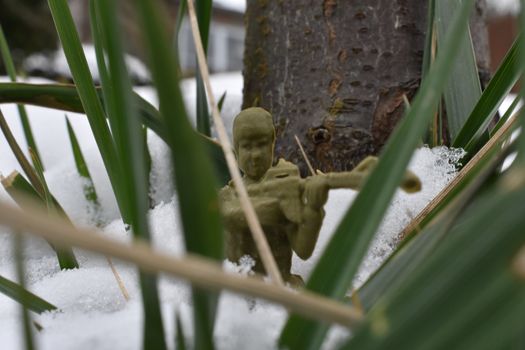 A Toy Soldier Taking Aim and Ready to Fight in Knee-Deep Snow
