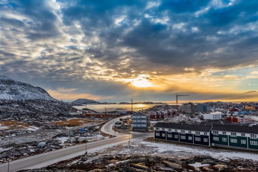 Arctic houses growing on the rocky hills in sunset panorama. Nuuk, Greenland