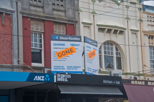 MELBOURNE, AUSTRALIA - JULY 30, 2018: Gone banner pasted on top of lease ads of office space above ANZ bank in South area of Melbourne Australia