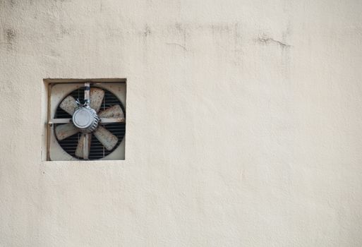 Old grey fan on creamy white wall