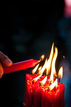 Hand lit red bright candles