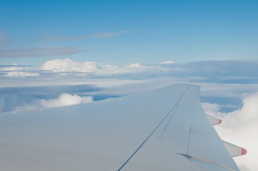 Wing of jumbo jet aircraft plane fly in the blue sky