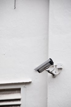 Surveillance camera on white wall