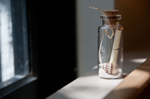 Little message in a bottle of sand and shell