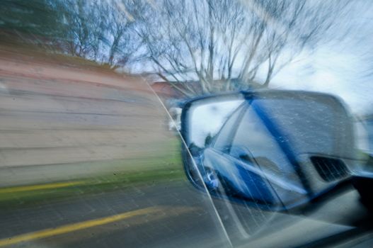 Side mirror of fast moving car