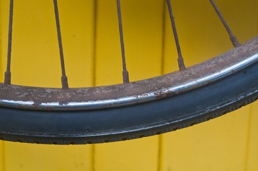 Classical bike wheel spke on yellow wall