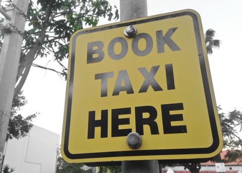 Book Taxi here yellow sign