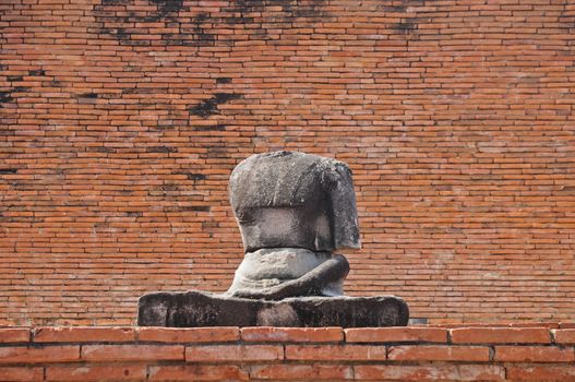 Sitting ancient Buddha statue in Thailand old brick temple