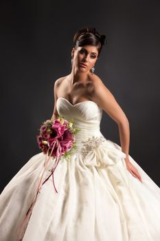 Young beautiful woman in a wedding dress on a studio background