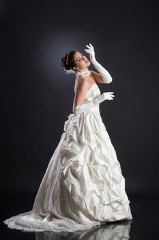 Young beautiful woman in a wedding dress on a studio background