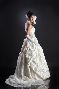 Young beautiful woman in a wedding dress on a studio background