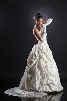 Young beautiful woman in a wedding dress on a studio background