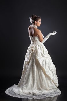 Young beautiful woman in a wedding dress on a studio background