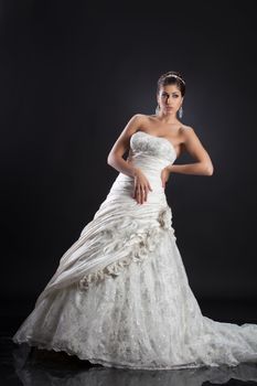 Young beautiful woman in a wedding dress on a studio background