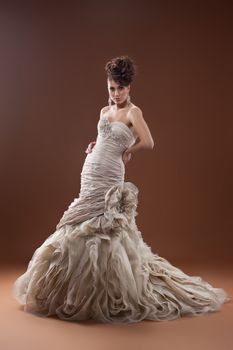 Young beautiful woman in a wedding dress on a studio background